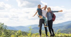 Family-Friendly Vacation Ideas Before Peak Summer: A family at the peak of a mountain overview